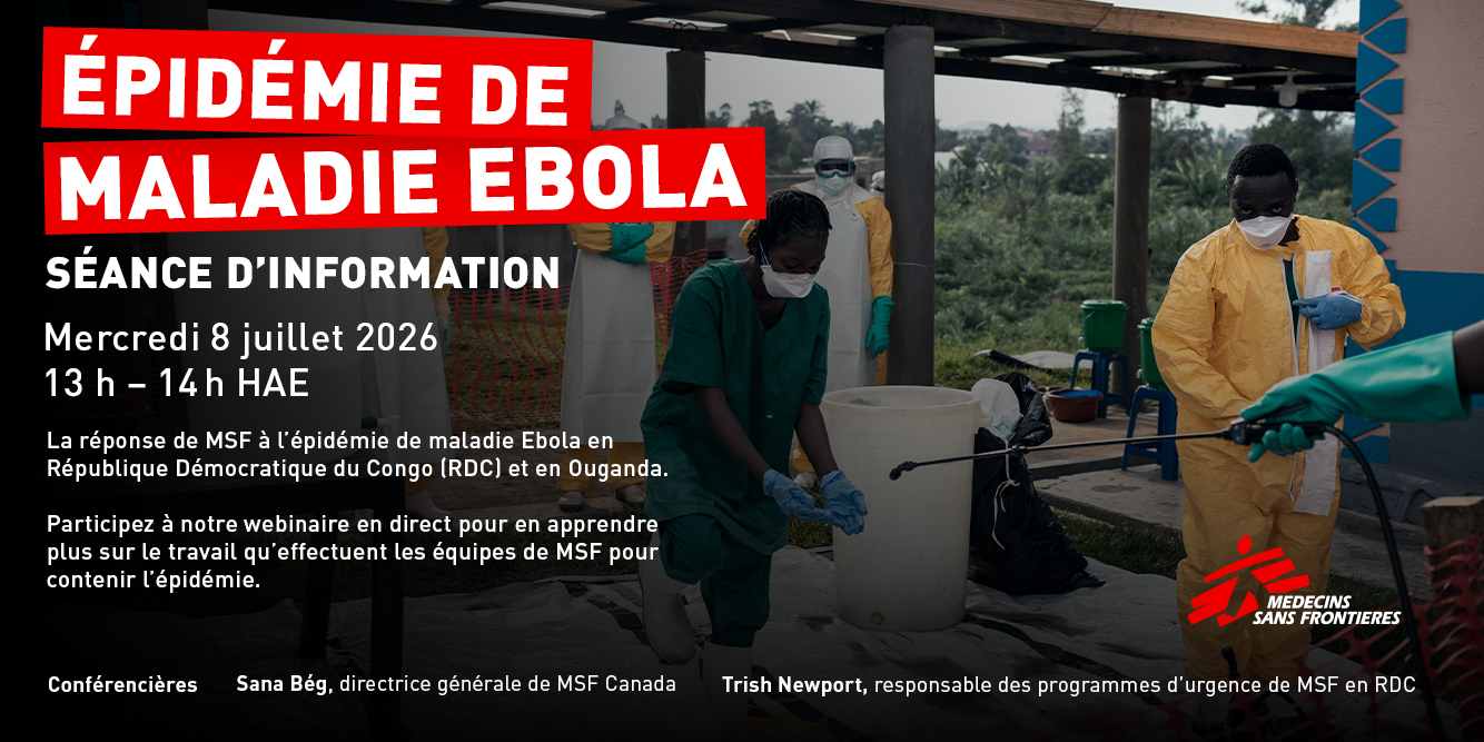 Un membre du personnel de MSF, v�tu d’un �quipement de protection individuelle, transporte des matelas entre les structures de toiles blanches du nouveau centre de traitement de la maladie Ebola � l’h�pital d’Elikya, � Bunia.
